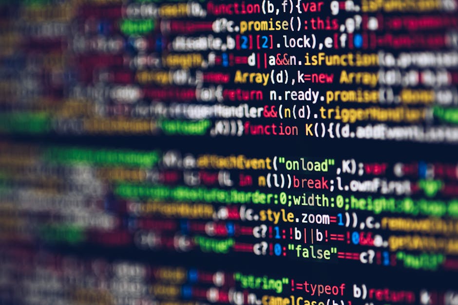 Close-up view of a computer screen displaying colorful lines of programming code in various colors including red, green, yellow, blue, and white on a dark background. The code consists of syntax eleme